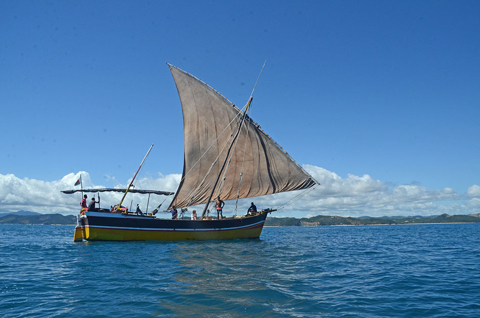 Ein traditionelles Segelboot segelt auf türkisfarbenem Wasser, ideal um das Unterwasserleben zu erkunden.