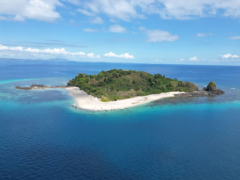 Tropische Insel umgeben von kristallklarem Wasser, ideal zum Tauchen und für marine Erkundungen.